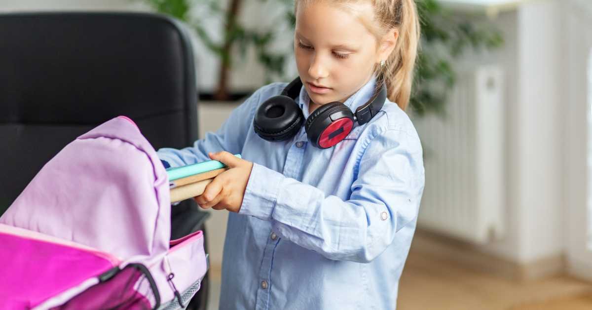 child organizing school bag and books at home