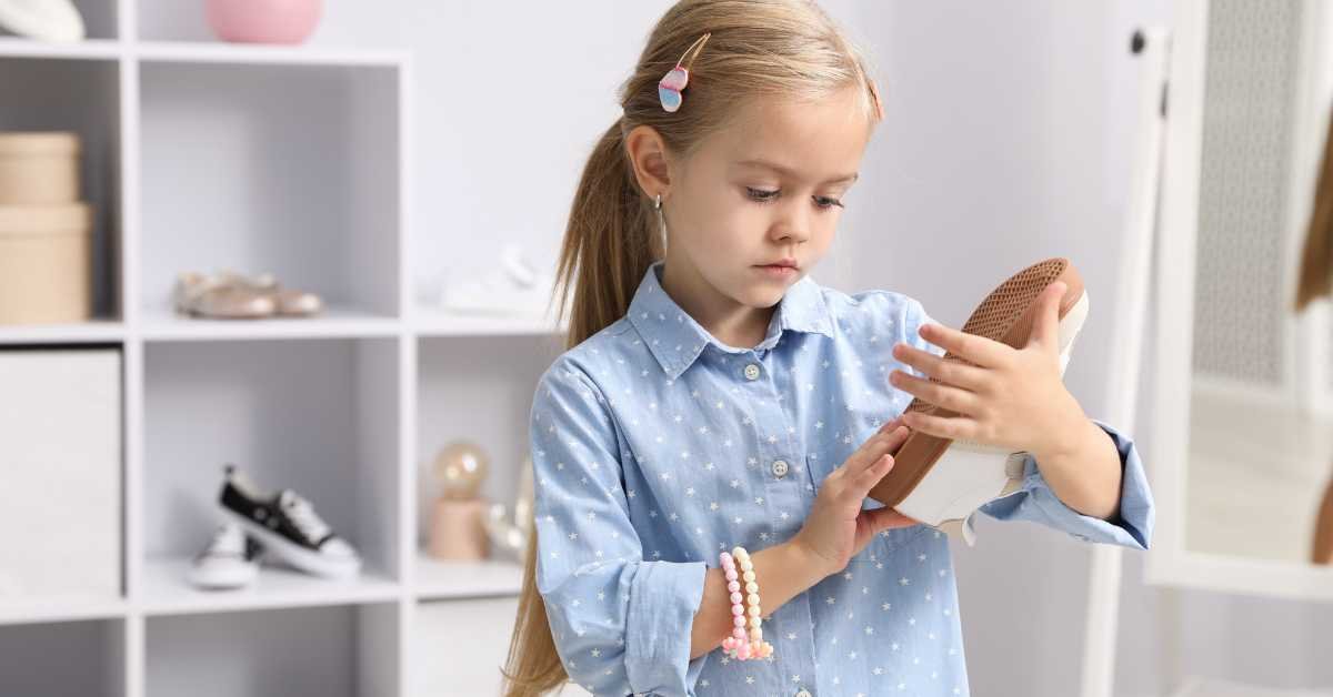 child putting shoes in rack after school 